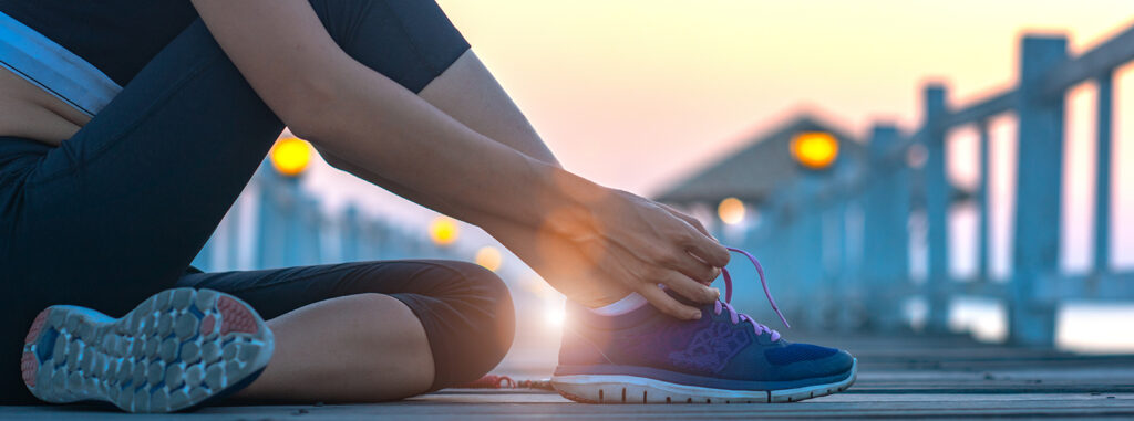 woman sitting on the wooden pier lace tie of the shoe, excercise running and jogging in daily morning healthy lady morning light